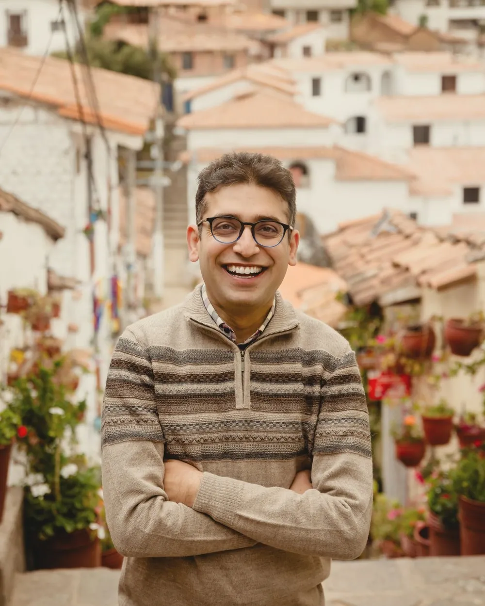Sameer Vermani smiling, with Cusco rooftops behind him
